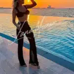 Sensual High Class Escort by infinity pool at sunset with luxury lifestyle vibe – Charlie London
