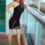 High-class escort posing in black dress