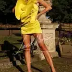 VIP companion Miami posing confidently in a bold yellow mini dress