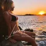 Monica enjoying sunset by the sea.