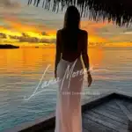 Back view of Alena at sunset in a flowing white dress.